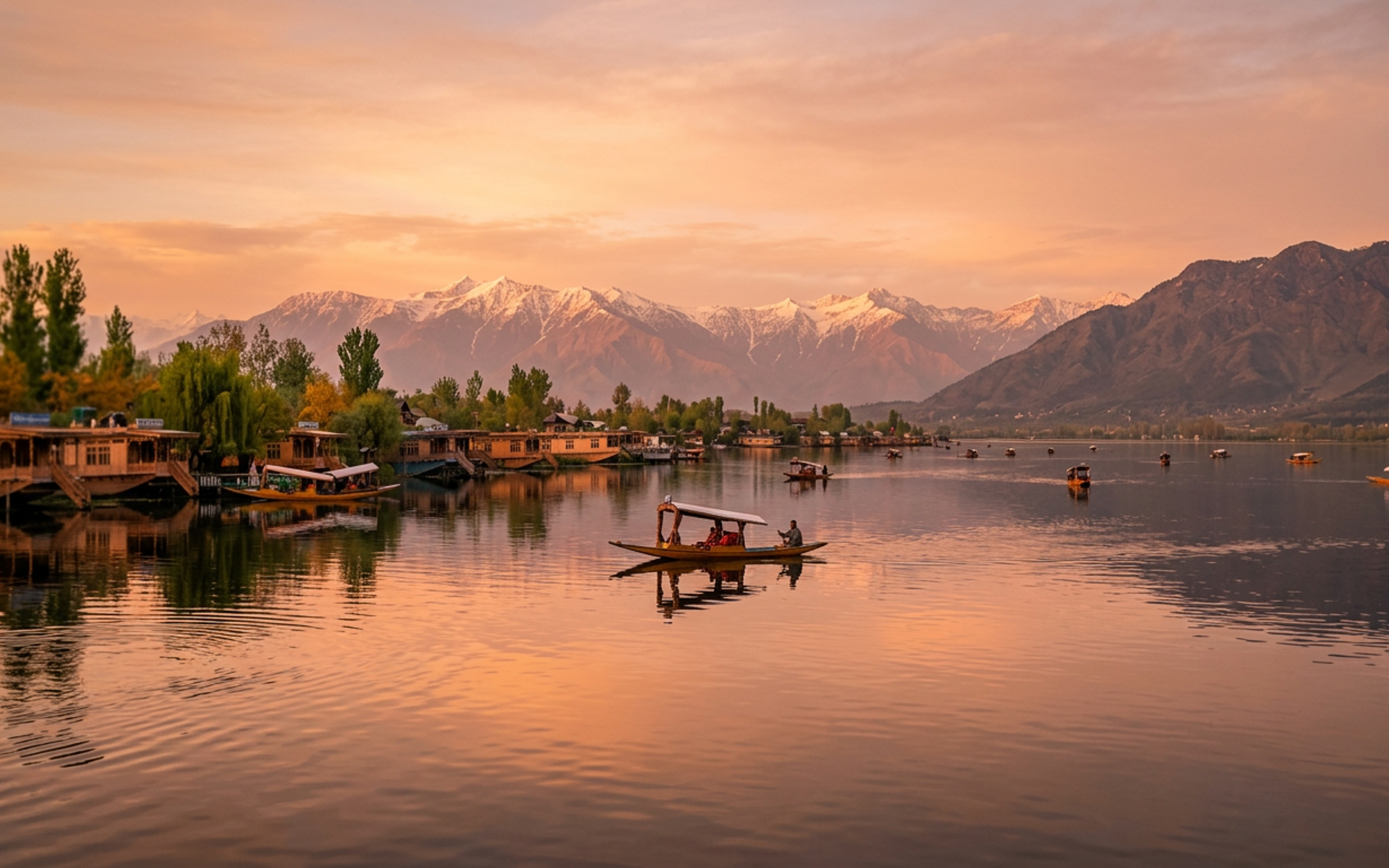 Golden hour view of Dal Lake in Srinagar, Kashmir with a shikara boat and snow-capped mountains